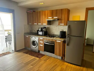 a kitchen with a refrigerator and a washer and dryer at Sidi Rahal Blue Beach in El Jadida