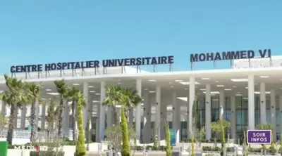 a large building with palm trees in front of it at A 2min hôpital M6,Proche d'Aéroport et la gare bouskoura in Bouskoura