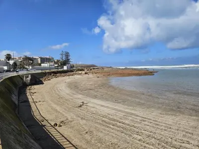 a beach with footprints in the sand and the ocean at Vakantie app charmante Harhoura in Temara