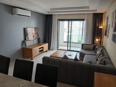 a living room with a couch and a table at Vakantie app charmante Harhoura in Temara
