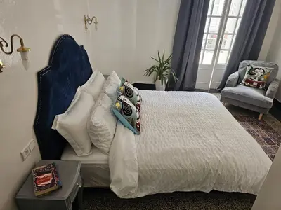 a bedroom with a bed with pillows and a chair at Cosy 2BR in Heart of Casablanca in Casablanca