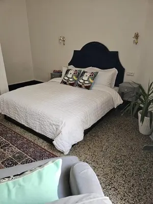 a bedroom with a bed with white sheets and a plant at Cosy 2BR in Heart of Casablanca in Casablanca