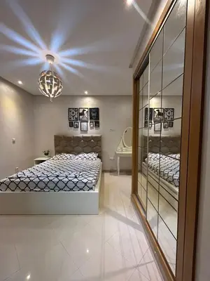 a bedroom with two beds and a mirror at Maison à louer à Mohammedia in Mohammedia