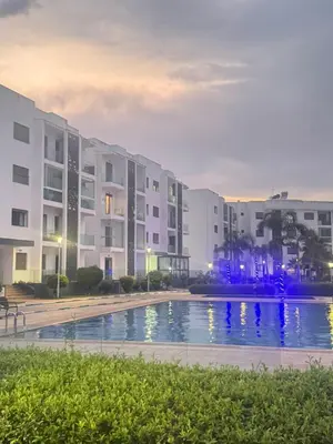 a swimming pool in front of buildings at night at Maison à louer à Mohammedia in Mohammedia