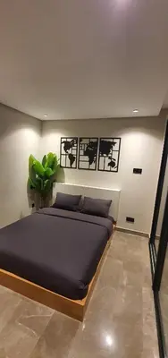 a bedroom with a bed and a plant on the wall at Maârif Penthouse in Casablanca