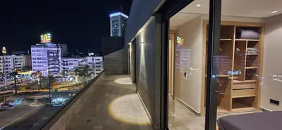 a balcony with a view of a city at night at Maârif Penthouse in Casablanca
