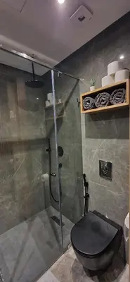 a bathroom with a shower with a black toilet at Maârif Penthouse in Casablanca