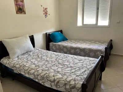 a bedroom with two beds and a window at Beautiful 2 bedrooms apartment in Bouznika in Bouznika