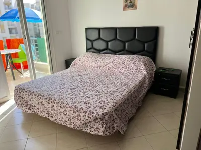 a bedroom with a bed with a black headboard at Beautiful 2 bedrooms apartment in Bouznika in Bouznika