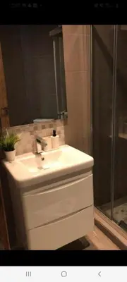 a bathroom with a white sink and a shower at Apparemment sur mer avec piscine al Mansouria in O Ben Slimane