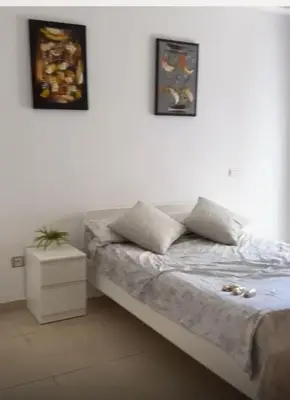 a bedroom with a bed with two pictures on the wall at Apparemment sur mer avec piscine al Mansouria in O Ben Slimane