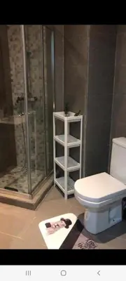 a bathroom with a shower and a toilet and a towel at Apparemment sur mer avec piscine al Mansouria in O Ben Slimane
