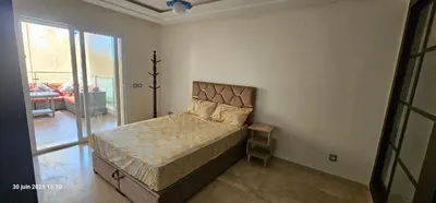 a bedroom with a bed and a large window at Appartement tamaris in Sidi Rahal