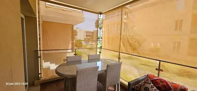 a balcony with a table and chairs and a window at Appartement tamaris in Sidi Rahal