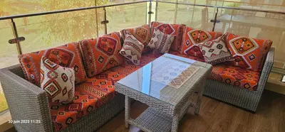 a couch with a table and pillows on it at Appartement tamaris in Sidi Rahal