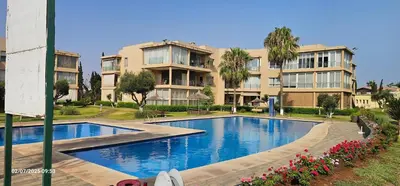 a large apartment building with a large swimming pool at Appartement tamaris in Sidi Rahal