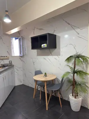 a kitchen with a table and a tv on a wall at Appartement au centre ville pour les mariés seulement in Rabat