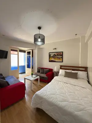 a bedroom with a large bed and a red couch at Appartement au centre ville pour les mariés seulement in Rabat