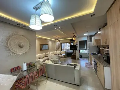a living room with a couch and a table at Appartement Balneaire avec piscine à El Mansouria in Mansouria