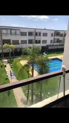 a view of a building with a pool and palm trees at Puerto Banus in Mansouria