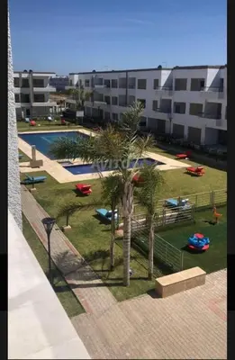 a view of a park with palm trees and a building at Puerto Banus in Mansouria