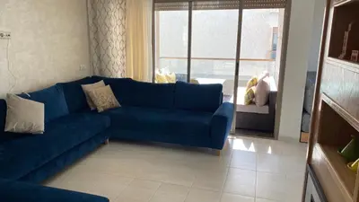 a living room with a blue couch and a window at Puerto Banus in Mansouria