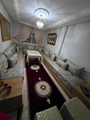 a living room with a couch and a table at Appartement souka fitness in Bouznika