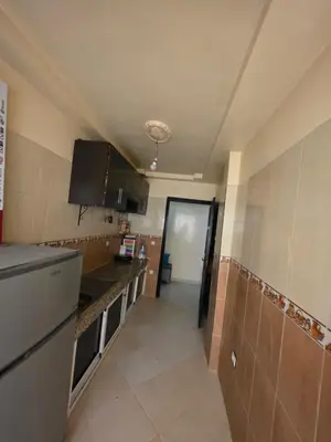 a small kitchen with a sink and a refrigerator at Appartement souka fitness in Bouznika
