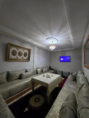 a living room with a couch and a table at Appartement souka fitness in Bouznika