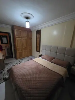 a bedroom with a large bed with a large headboard at Appartement souka fitness in Bouznika