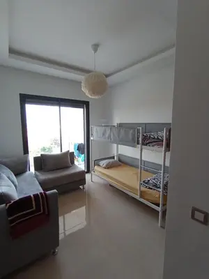 a living room with bunk beds and a couch at Charming appartement in Bouznika in Bouznika