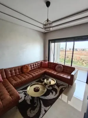 a living room with a brown couch and a table at Charming appartement in Bouznika in Bouznika