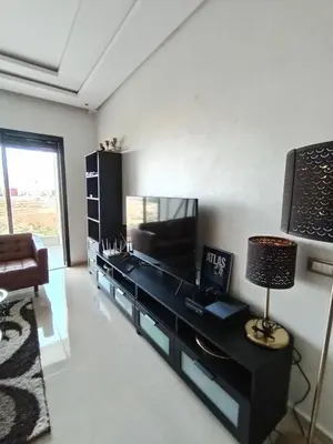 a living room with a black table and a lamp at Charming appartement in Bouznika in Bouznika