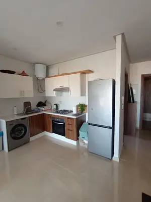 a kitchen with a white refrigerator and a stove at Charming appartement in Bouznika in Bouznika