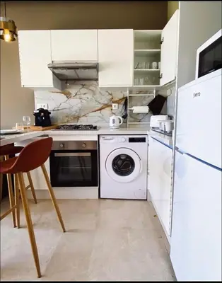 a kitchen with a white refrigerator and a washing machine at Concept Studio-valfleuri in Casablanca