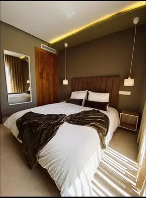 a bedroom with a large bed and a mirror at Concept Studio-valfleuri in Casablanca