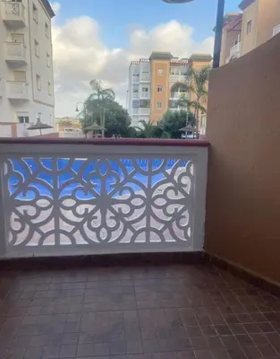 a fence with a blue gate in a city at Casa Amy in Mohammedia