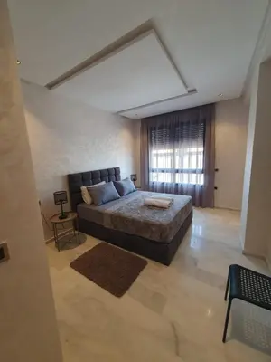 a bedroom with a large bed and a window at Studio Parc Mohammedia in Mohammedia