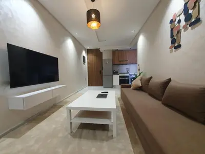 a living room with a couch and a tv at Studio Parc Mohammedia in Mohammedia