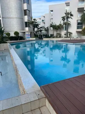 a large swimming pool in front of a building at beach front gardens in Mohammedia