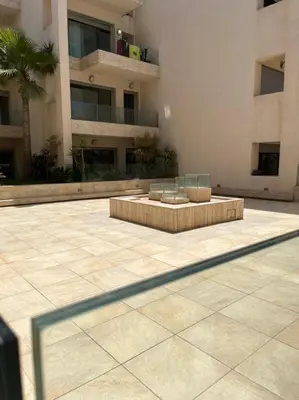 a building with a bench in the middle of a courtyard at beach front gardens in Mohammedia