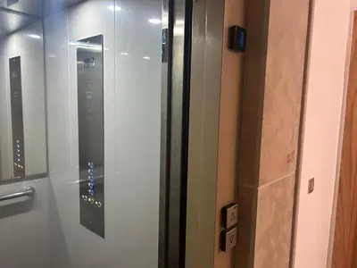 a glass door of a elevator in a room at Belle Appt vue sur Piscine à Bouznika plage in Bouznika
