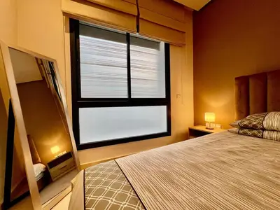 a bedroom with a bed and a large window at Rihla Stays - Anfa City in Casablanca