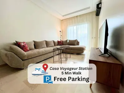 a living room with a couch and a television at Casablanca Central Suites - Casa Voyageurs in Casablanca