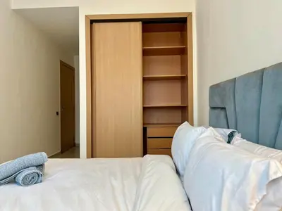 a bedroom with a white bed and a closet at Casablanca Central Suites - Casa Voyageurs in Casablanca