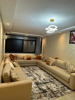 a living room with a large couch and a television at Appart a 1 minutes de la plage in Casablanca