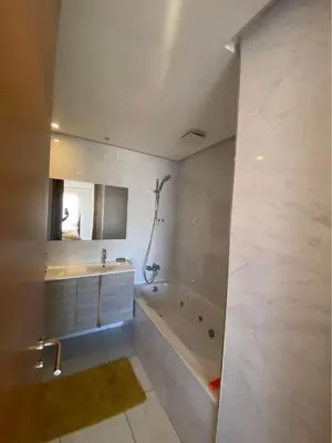 a white bathroom with a tub and a sink at Résidence yassmin in Rabat