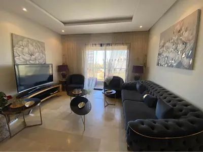 a living room with a couch and a tv at Résidence yassmin in Rabat