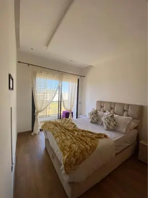 a bedroom with a large bed with a large window at Résidence yassmin in Rabat