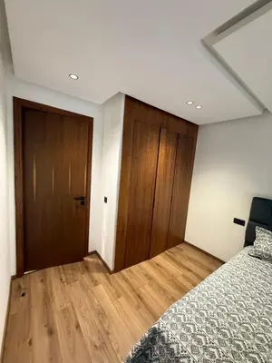 a bedroom with a bed and a wooden door at Appartement maarif in Casablanca
